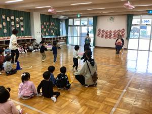 異年齢児で菱餅に見立てた箱を積んで運んでいます