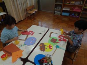 子ども達が、画用紙で鬼のお面をつくっています