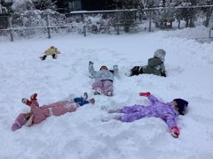 雪の上に寝転がって遊んでいます