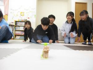 人形を倒さないようにテープを巻き取っています
