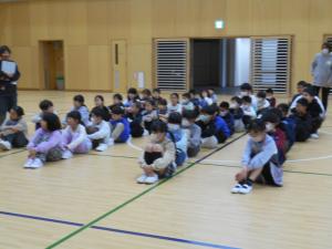 体育館の床に座っています
