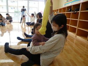 こどもが揺れるタオルをよく見て掴まえようとしています