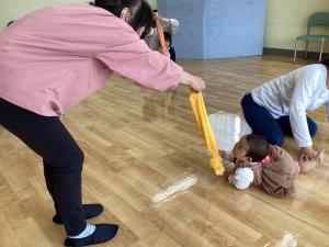 先生の持つタオルを追いかけてハイハイしています