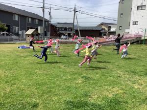 めろん組が小さいこいのぼりを持って走っています