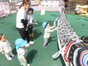 さくらんぼ組がテラスに飾られたこいのぼりを触っています