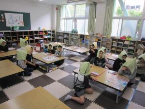 防災頭巾をかぶって話を聞く子どもたち