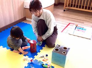 こいのぼりの磁石玩具をくっつけて遊ぶ男児の画像