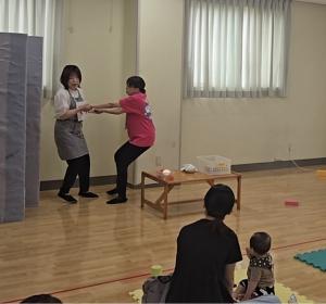 嫌がるこどもの手を引いて帰ろうとしている母です