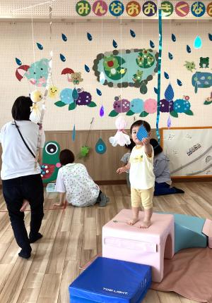 雨のつぶに触れる女児の画像