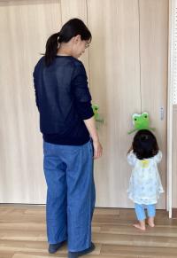 カエルの壁掛け玩具で遊ぶ女児の画像