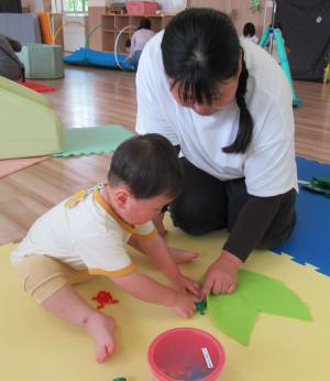 かえるの玩具で遊ぶ母と男児の画像
