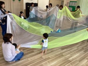 オーガンジーの布にボールを入れてみんなで遊ぶ画像