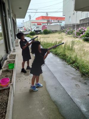見学の妹と水鉄砲を試し撃ちしている画像