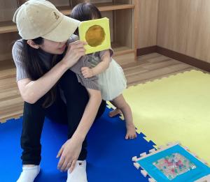 サンキャッチャーを覗く男児の画像