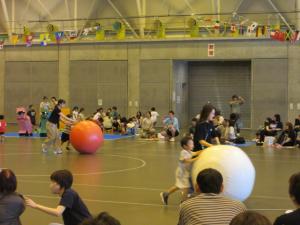 4歳児親子が、卵に見立てた大玉を転がしている画像