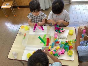 異年齢の友達と七夕の笹飾りを制作している画像