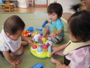 玩具で遊ぶ0歳児の画像