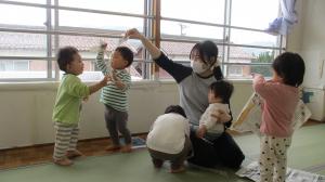 新聞遊びをする1歳児の画像