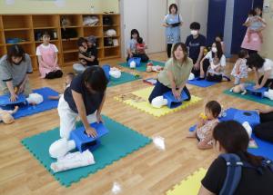 小児用の人形を使って片手でマッサージしている画像