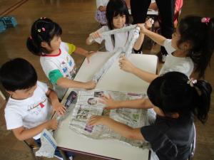 新聞紙で友達と一緒にドーナツを作っている画像