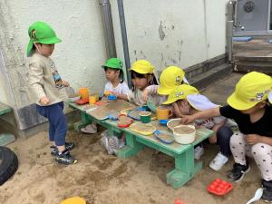 砂場でおままごとをしている画像