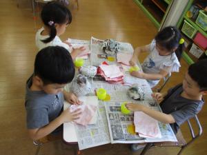 新聞を丸めてりんご飴を作っている画像