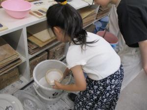 釉薬をつける児童の画像