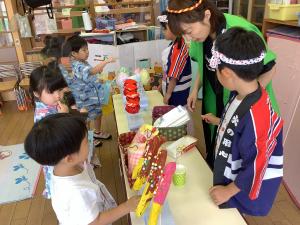 大きいクラスの友達が作ったおいしそうな食べ物を選んでいる画像