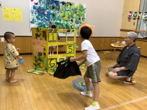 的当てゲーム屋さんで、狙いを定めてボールを投げる画像