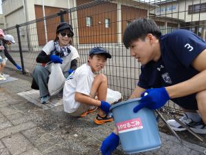清掃活動をしている親子と選手の画像