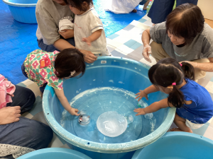大きな氷に手をのばして触ろうとするこども達の画像