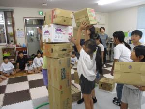 自分よりも高い位置にダンボールを積んでいる画像