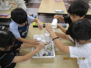 紙コップを使ったクレーンで遊んでいる画像