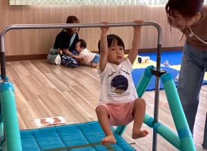 鉄棒にぶら下がる男児の画像