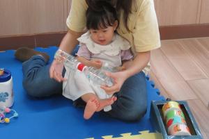 ペットボトルの玩具で遊ぶ女児の画像