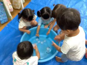 タライの氷を触って遊んでいる画像