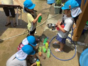 外で色水遊びをしている画像