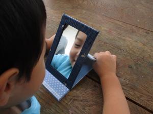 鏡をのぞき込む幼児の画像