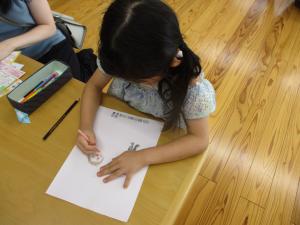 似顔絵を描く幼児の画像