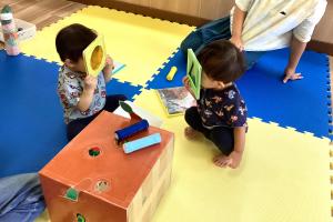 カラーセロファンの玩具で遊ぶ男児たち