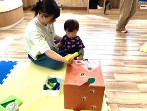 磁石の虫の玩具をくっつけて遊ぶ母と男児