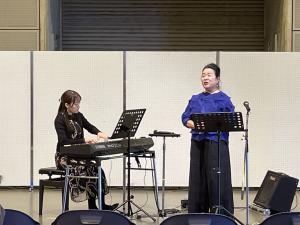 歌とキーボードによる演奏の写真