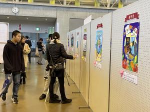 ポスター展示を見る人々の写真