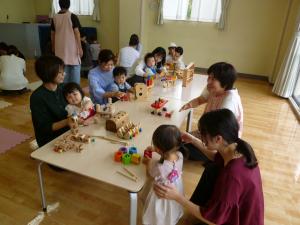 机を囲んでみんなでおもちゃに触れている様子