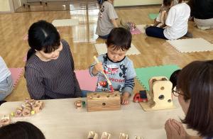 穴の中に入った虫を取り出すおもちゃで遊んでいる様子