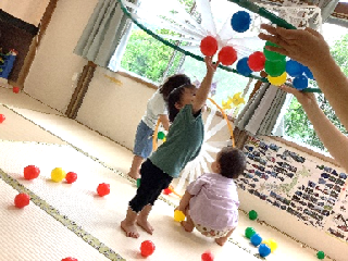 さくらんぼ組がカラーボールを貼って遊んでいます