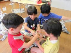 友達と一緒に新聞紙を使って遊んでいます。