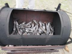 ホイルに包んださつまいもを窯に入れています。