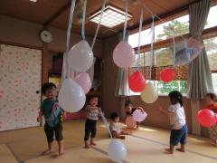 部屋の中で風船に触れて遊んでいます。