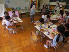 みんなでクッキングした夏野菜カレーを味わっています。